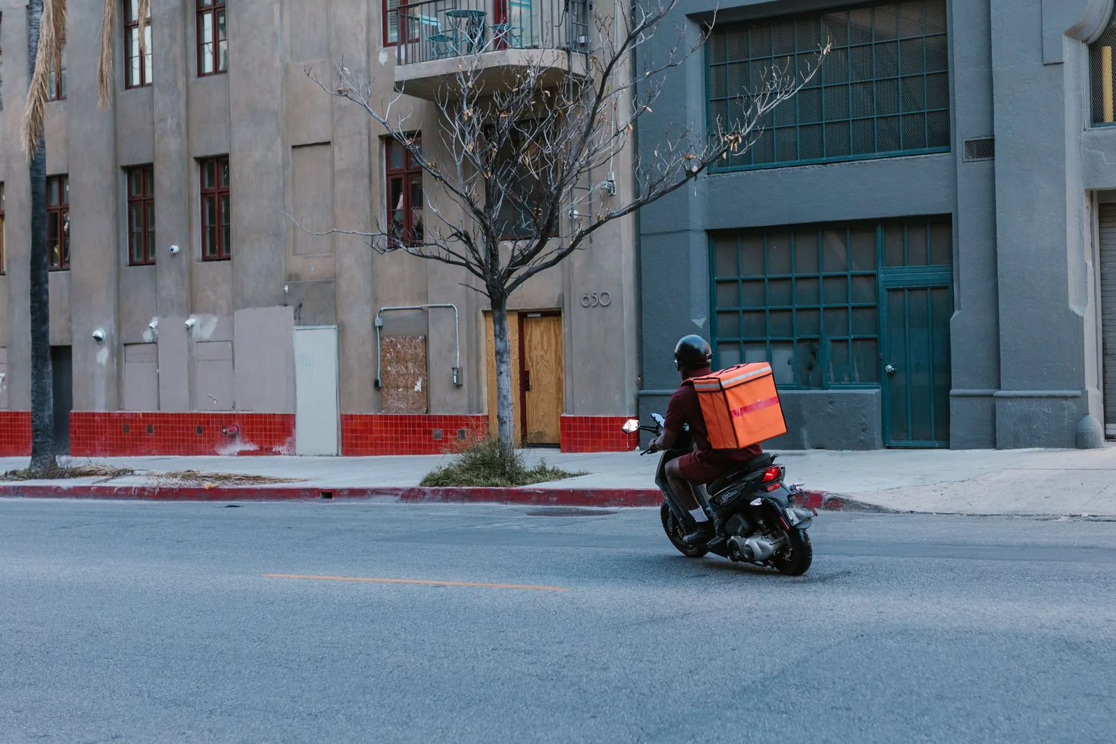Entregador de moto faz entrega de delivery pela rua da cidade